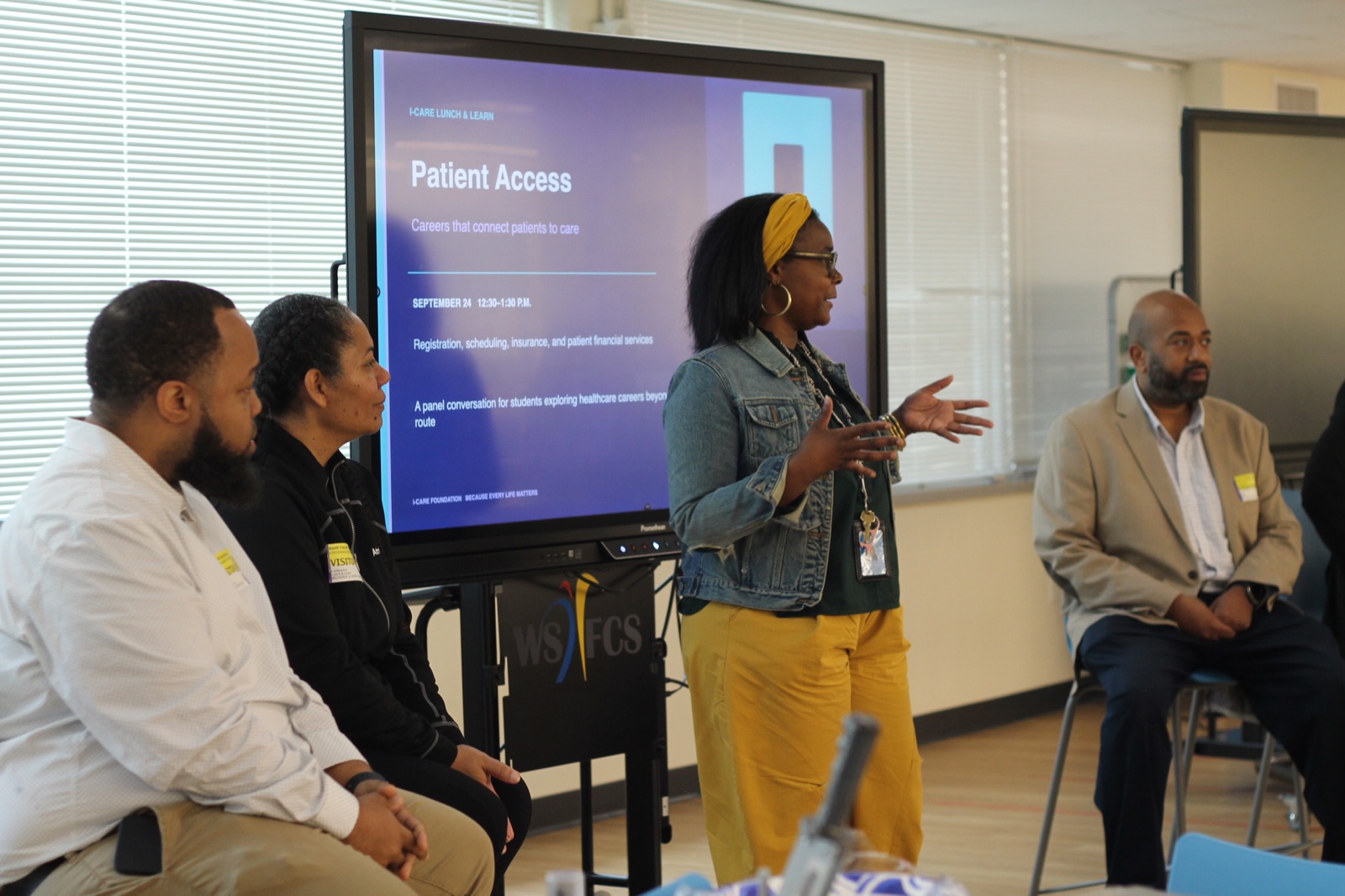 A community professional speaks to students in front of the Patient Access presentation.