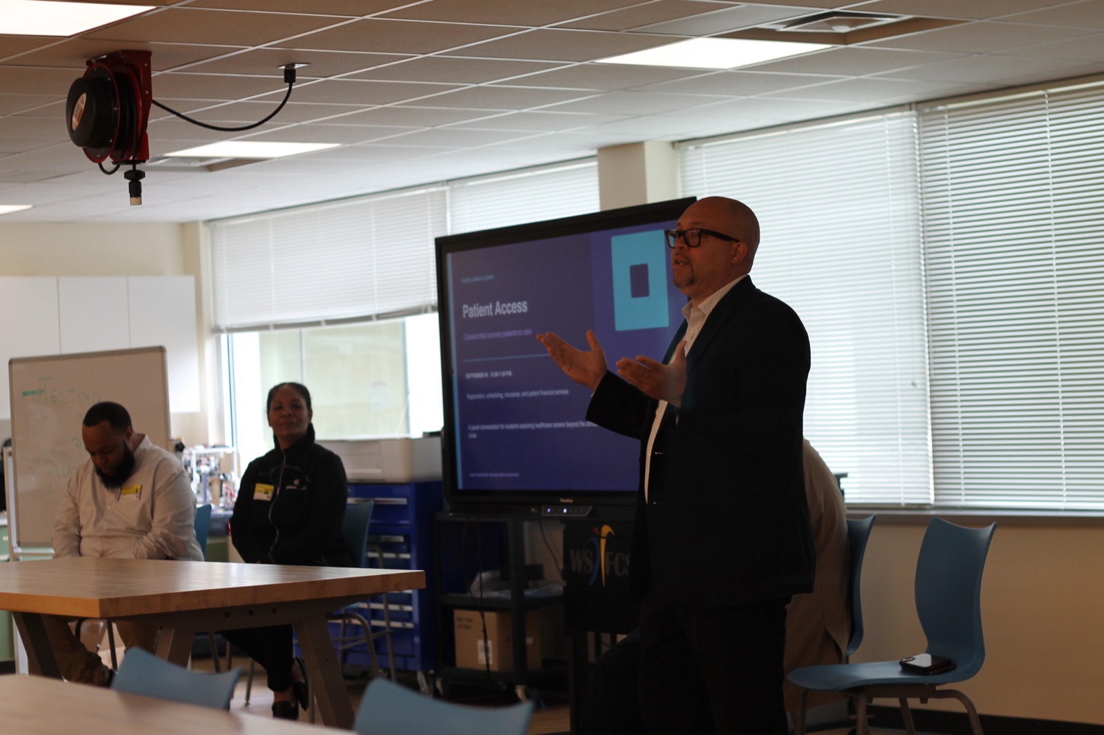 A healthcare professional speaks to students during the I-CARE Patient Access session.