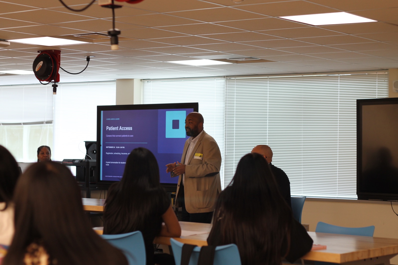 A guest presenter welcomes students to the I-CARE Patient Access session.
